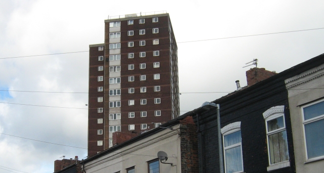 a residential tower block poking over the top of terraced houses in eccles